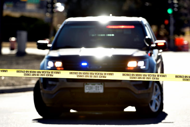 Police officers investigate one of several crime scenes from a shooting spree at 8th Avenue and Zuni Street on December 28, 2021 in Denver, Colorado. A disabled vehicle with a flat tire and shot out window remains in the intersection. A suspect went on a shooting spree on Monday night that spanned two cities, Lakewood and Denver, and claimed the lives of four people and wounded three people including a Lakewood police officer. 