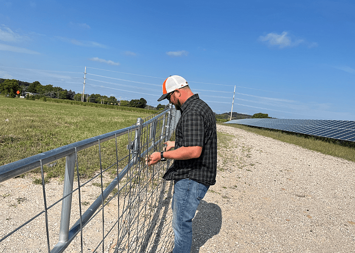 image of Operations manager Bart Hautala closes the gate at the Heritage Sustainable Energy solar array in Traverse City, Michigan.