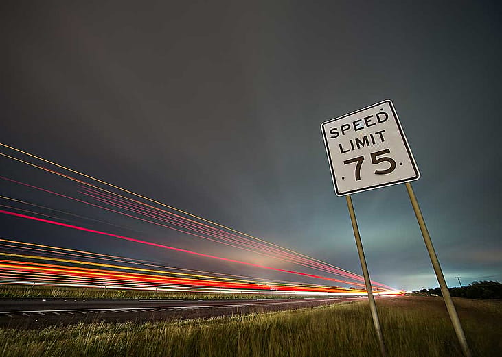 speed limit sign with motion blur of car headlights 