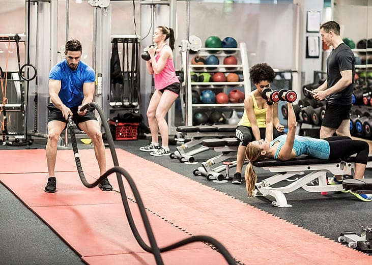 five people working out in a gym on doing different exercises