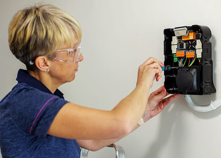 woman installing EV charger at home