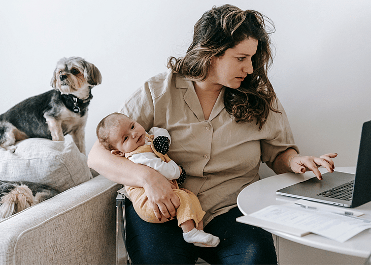 parent juggling pet and baby while working from home