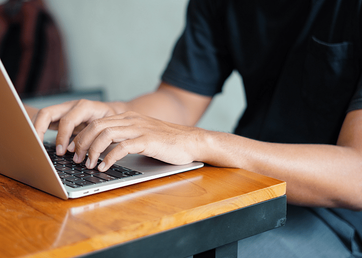 closeup hands of student on a laptop at a desk