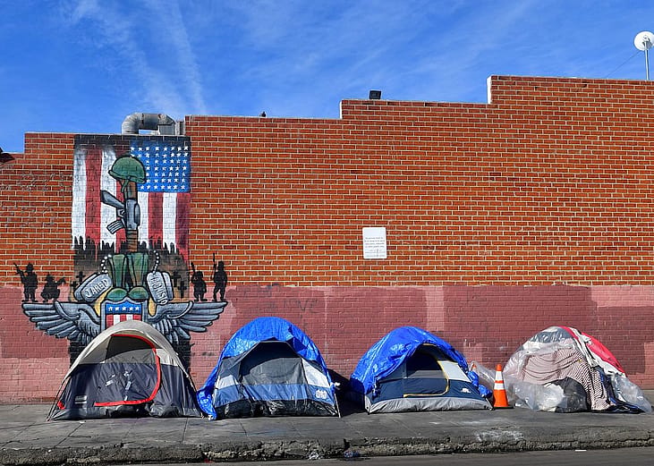 Tents for the homeless line a sidewalk in Los Angeles, California.