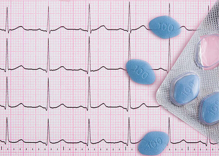 A graphic of a heart rhythm background with an overlay of blue pills.