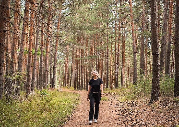 Woman connecting with nature, forest bathing. 