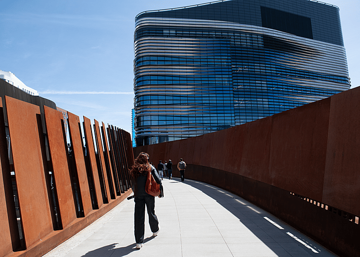 Students cross a pedestrian bridge to the EXP building at Northeastern University, which houses science, engineering and computational research departments.