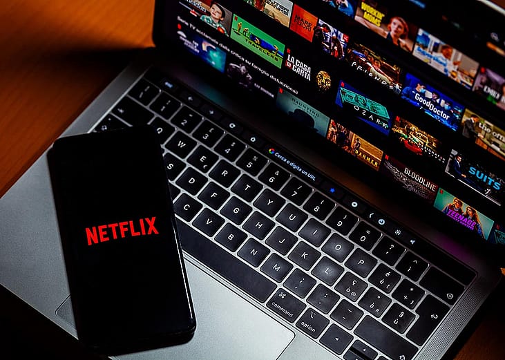 Phone and laptop displaying Netflix selections.
