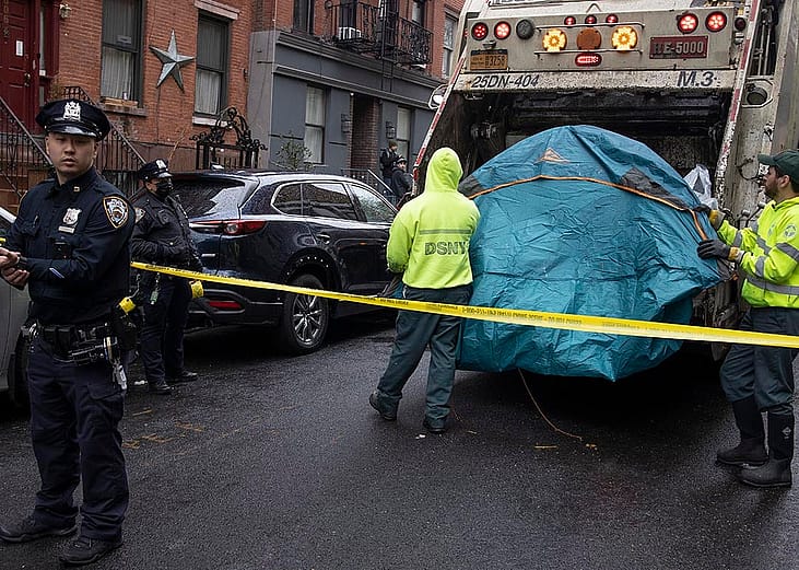 Police enforce a sweep of a homeless encampment, throwing tents and other possessions of the homeless in a trash truck in the East Village neighborhood of New York City.