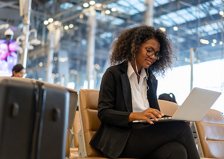 Businesswoman in airport using a laptop while waiting for flight.