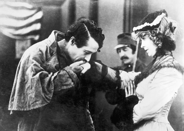 A man greets a woman with a kiss on the hand in a scene from 'Birth of a Nation' (1915)