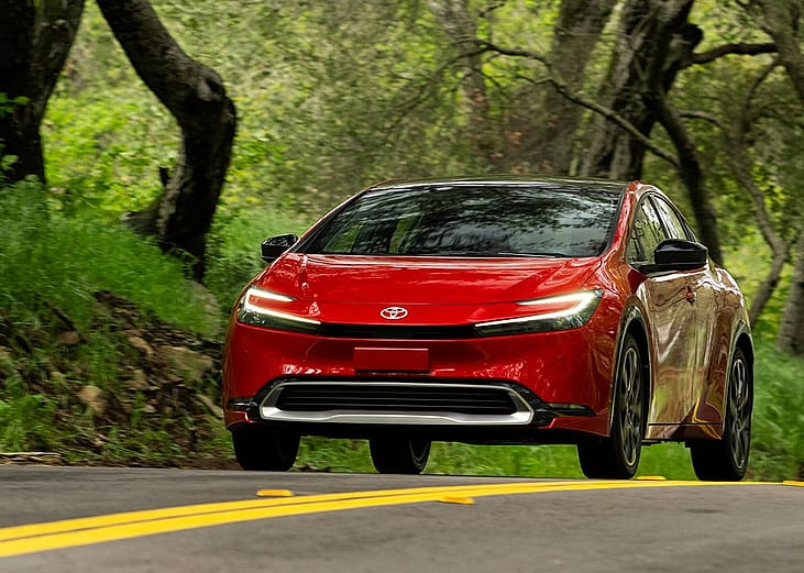 A red 2025 Toyota Prius on the road.