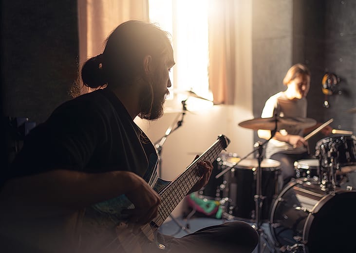 Band members such as a guitarist and drummer during a rehearsal.