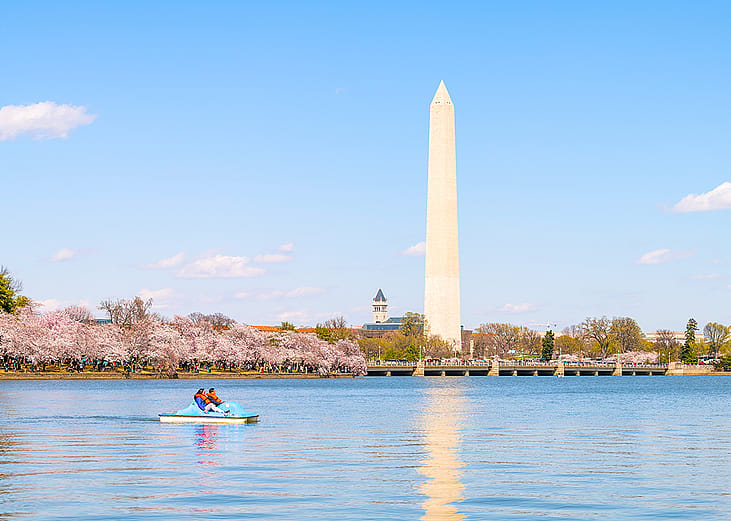 A couple on a pedal boat at the Tidal Basin with a view of the Washington Monument.
