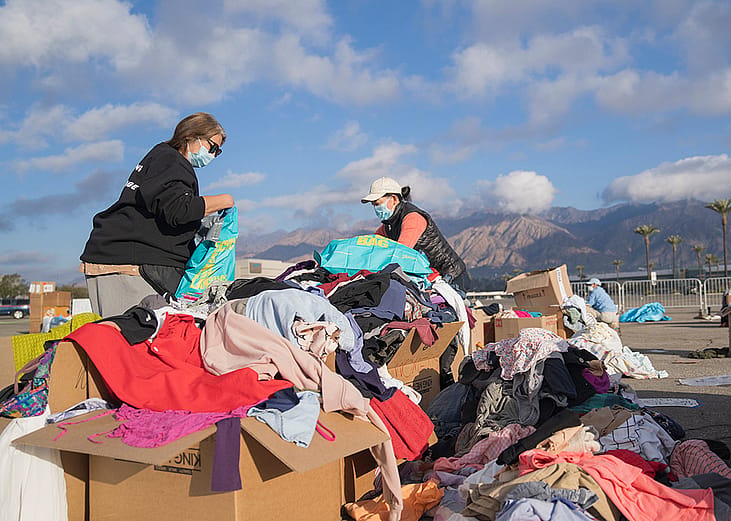 Volunteers sort through piles of clothing and textile donations made to California wildfire victims.