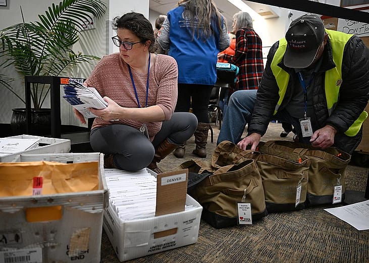  Denver Elections personnel administrator Elizabeth Littlepage, left, and election worker William Goad, sort through ballots that need to go to specific counties at the Denver Elections Division.