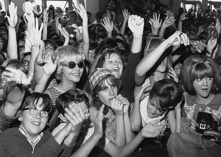 Sreaming fans cheer for rock and roll musicians on American Bandstand in the mid 1960s.