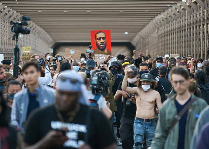 Marchers cross the Brooklyn Bridge demanding police reform after a commemoration to honor the anniversary of George Floyd's death on May 25, 2021 in New York City.