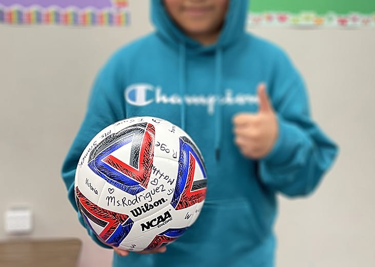 A fifth grader who left Areli Rodriguez's Texas classroom because his family feared being detained by immigration agents holds the signed soccer ball he received as a parting gift.
