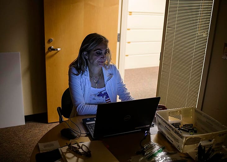 Election clerk working in a dark office on a computer.