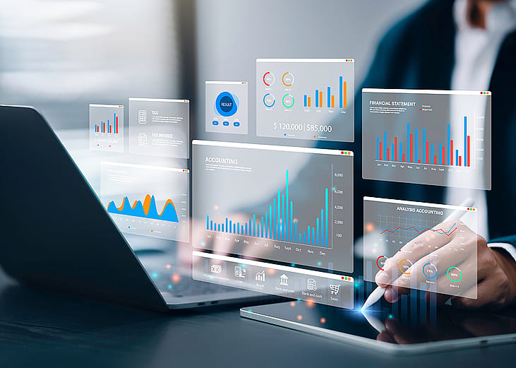 Accountant using a laptop and digital tablet with holographic visualizations of an accounting software.