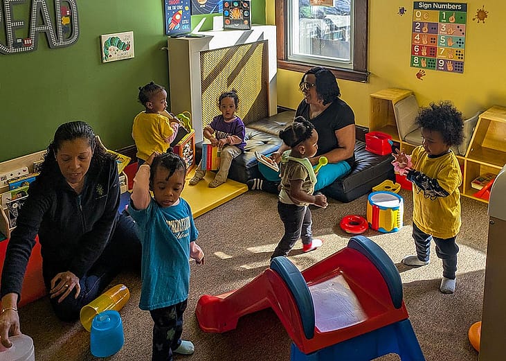 Toddlers play in a colorful room at Sandra Dill’s family child care in a colorful room.