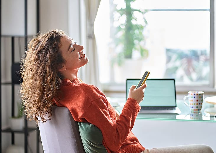 Young woman happily relaxing during a break at work showing a positive work-life balance.