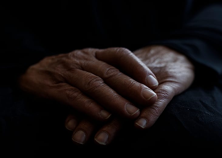 Hands of someone who is staying at a homeless shelter for domestic violence survivors, where funding cuts will impact services.