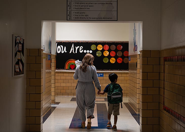 An English language teacher leads a student to their classroom at George Mason Elementary School in Alexandria, Virginia.