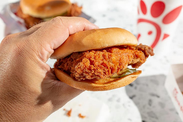 A view of a hand holding a Chick-Fil-A chicken sandwich.
