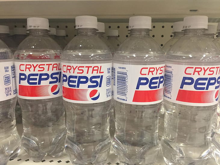 Crystal Pepsi plastic soda bottles on the store shelves for sale.