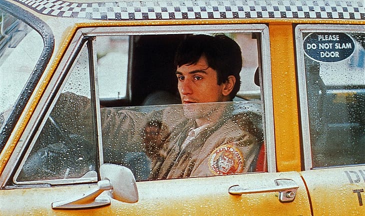 Robert De Niro behind the wheel of a taxi in a scene from the movie Taxi Driver.