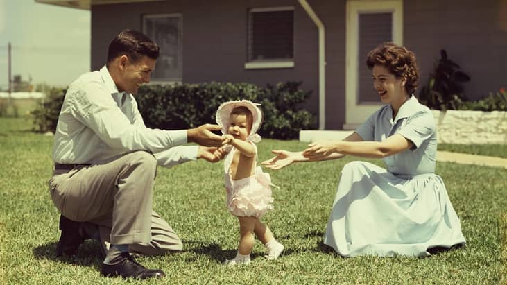 A mom and dad helped their baby learn how to walk in the 1960s