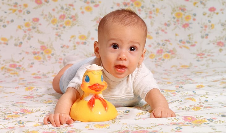 A portrait of a baby boy in the 1970s with his rubber ducky.
