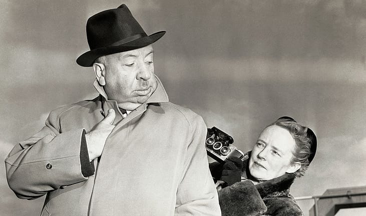 Alfred Hitchcock poses for a "sinister" type snapshot for his wife Alma Reville
