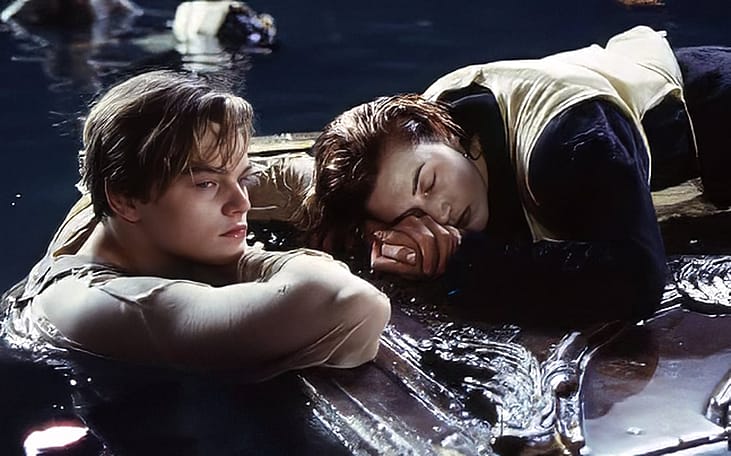 Leonardo DiCaprio and Kate Winslet in the final act of the film 'Titanic,' with Jack in the water as Rose rests on a floating piece of wood paneling.
