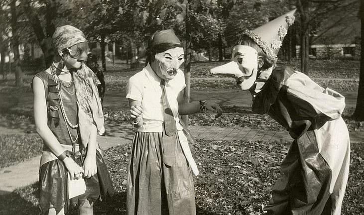 Three girls amuse each other with their masked costumes as they prepare for Halloween festivities in the College Hill neighborhood of Cincinnati, Ohio, 1929.