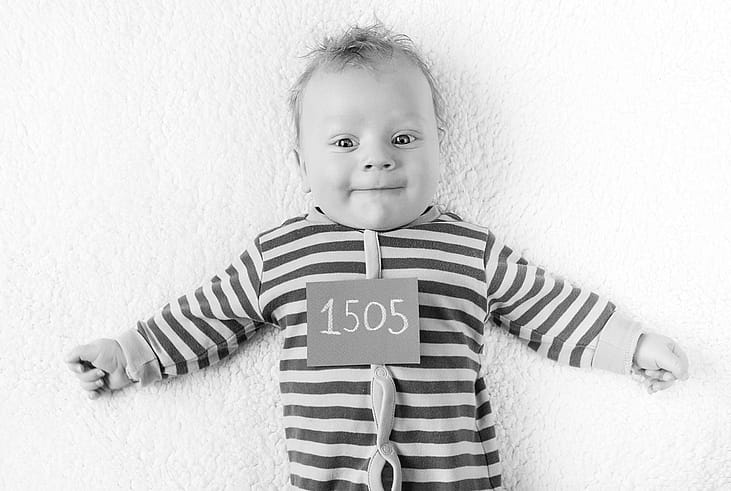 Baby in a striped jumper looking at the camera.