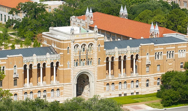 Aerial view of Lovett Hall at Rice University in Houston, with its arched Sallyport entrance, terracotta roofs and surrounding live oaks.