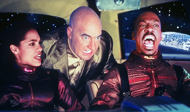 Rosario Dawson, Randy Quaid, and Eddie Murphy in a promotional still for the 2002 movie ‘The Adventures of Pluto Nash.’