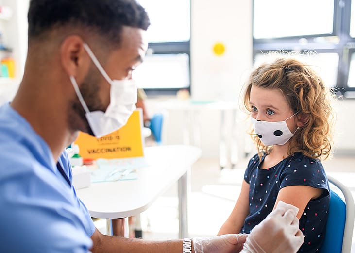 A toddler getting a vaccination from her pediatrician