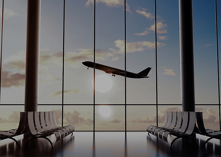 An airport terminal building with rows of empty chairs and airplane seen through the windows.