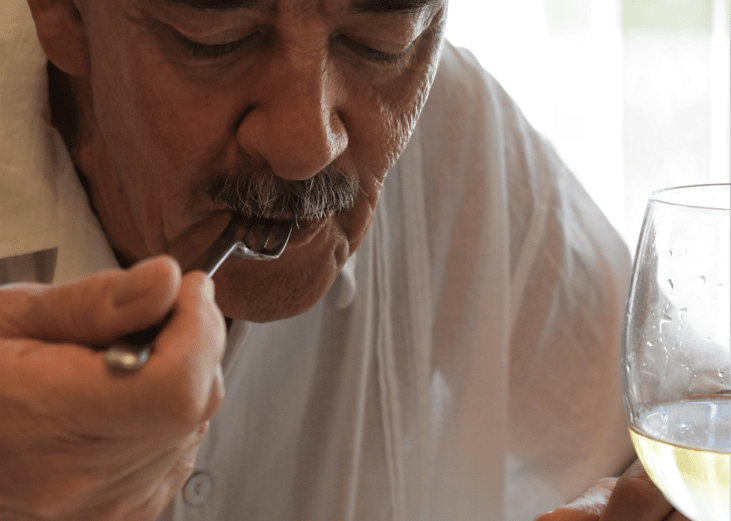 An older man savoring his meal.
