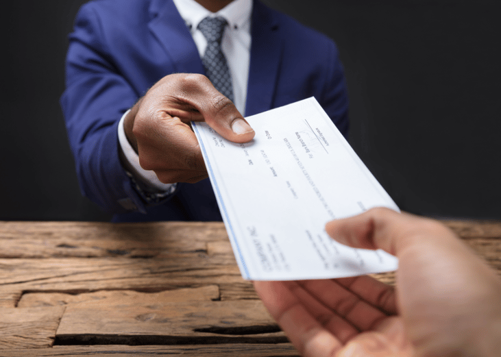 A business person handing a check to an employee