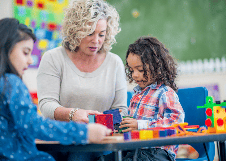 A preschool teacher with two students.