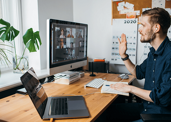 An employee on a video conferencing call via a computer in their home office