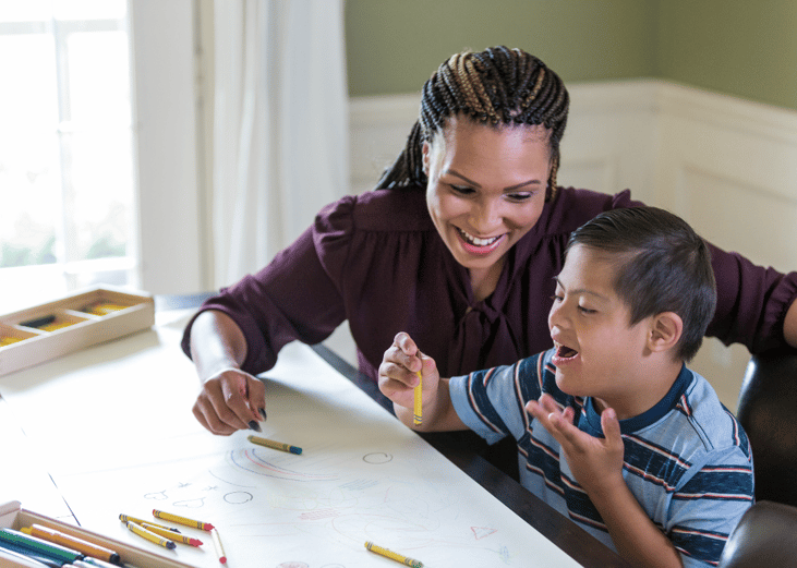 A teacher working with an excited special needs student.