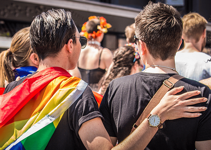 A gay couple at a pride parade.
