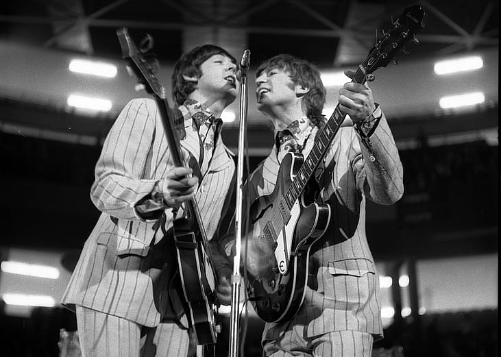 Beatles band members Paul McCartney (left), on bass, and John Lennon (right), on guitar, perform onstage at Olympia Stadium in Detroit, Michigan, in 1966.