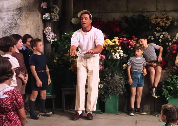 Gene Kelly talking to a group of kids.
